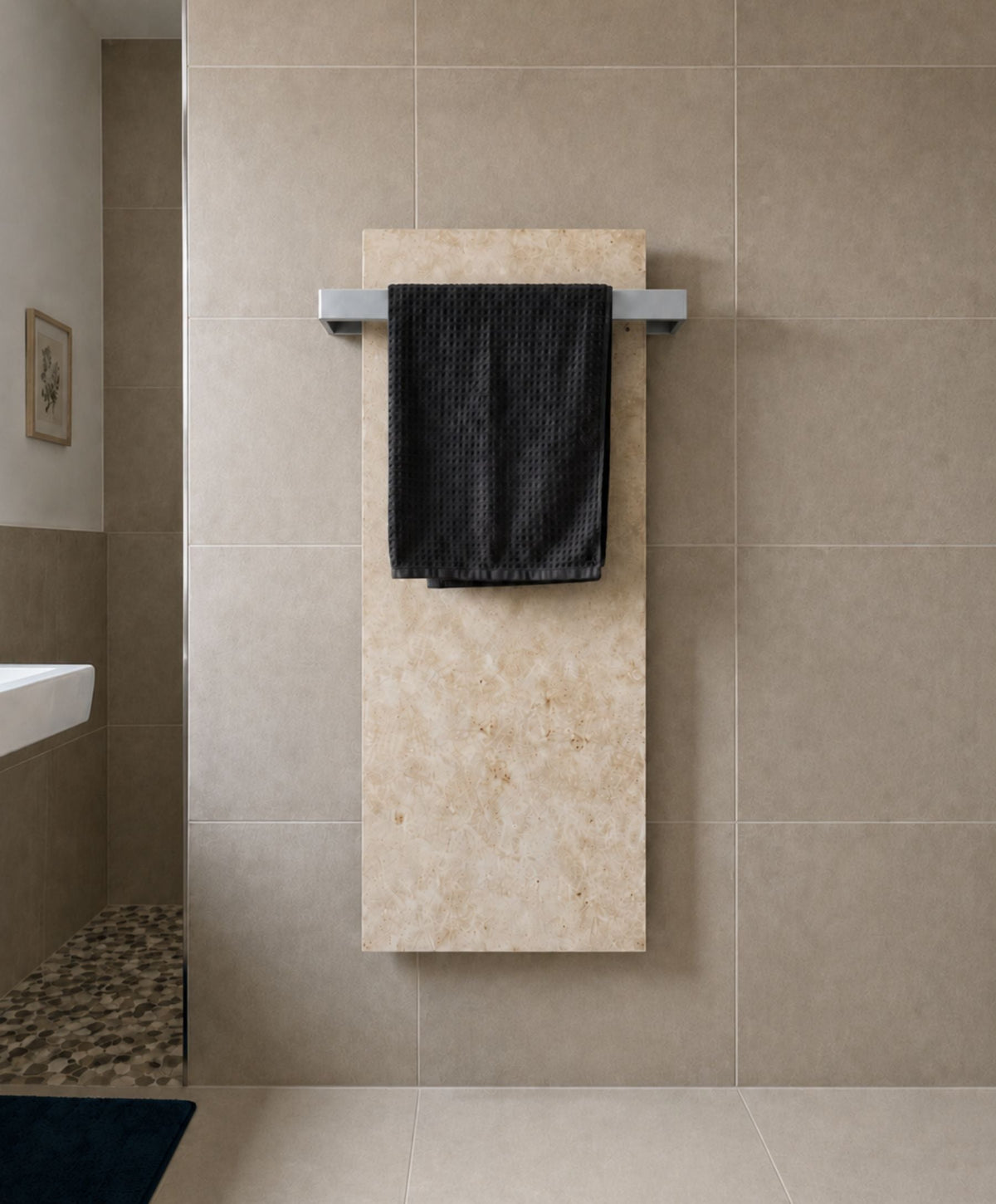 Beige Marwona Jura-Natursteinheizung mit silberfarbenem Handtuchhalter und dunklem Handtuch im Badezimmer.
